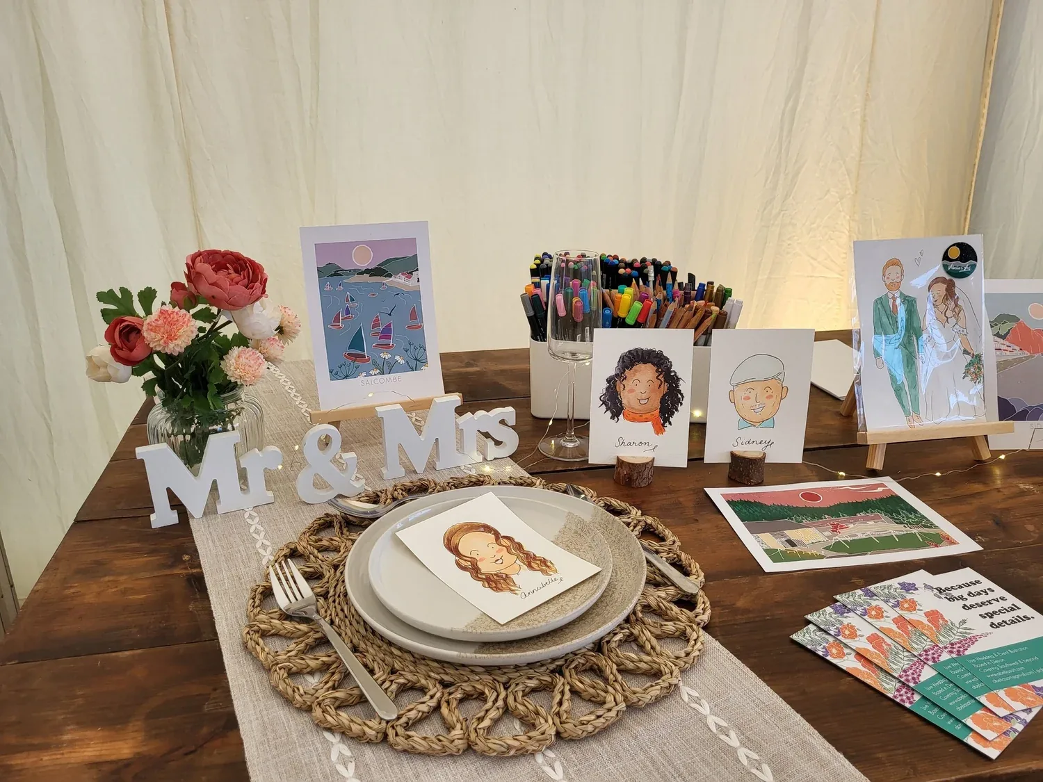 A wedding table with a Mr & Mrs sign and finished guest portraits on display